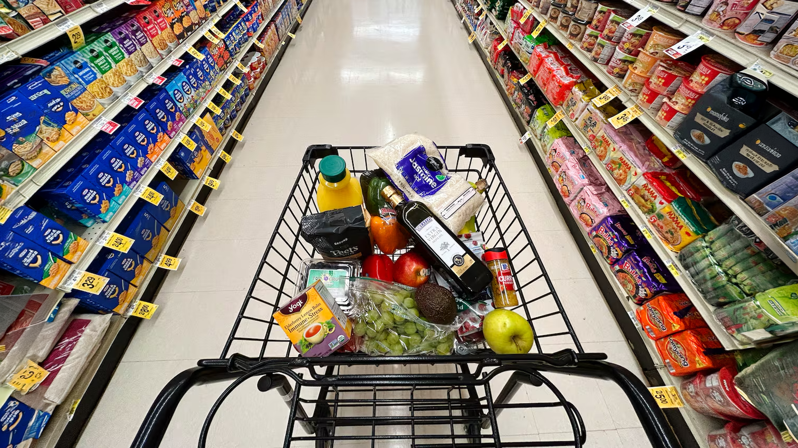Carrito de supermercado lleno de productos en un pasillo de tienda