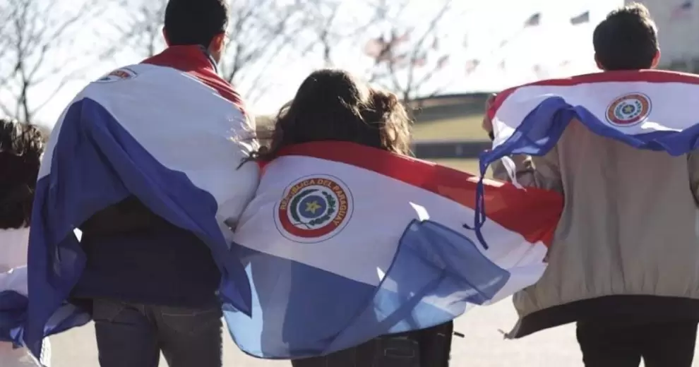 Personas envueltas en banderas de Paraguay caminando juntas